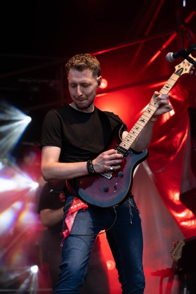 Gitarist van Bold speelt een solo tijdens een optreden