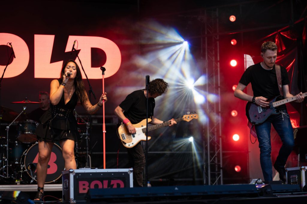 Frontvrouw van Bold zingt met de band op de achtergrond